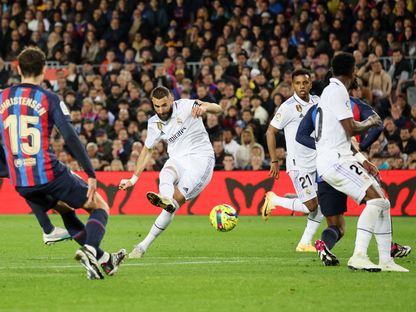 مهاجم ريال مدريد كريم بنزيما يسدد على مرمى برشلونة في الدوري الإسباني على ملعب "كامب نو" - 19 مارس 2023 - Reuters 