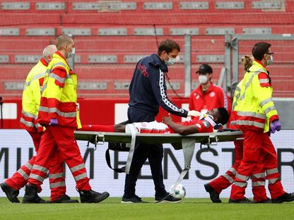 مهاجم ماينز النيجيري تايو أونيي محمولاً إلى خارج الملعب بعد إصابته - AFP