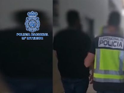 أحد عناصر الشرطة الإسبانية يقود أحد المتهمين مكبلا في قضية الاحتيال على اللاعبين البرازيليين - 11 أبريل 2023 - TWITTER/@policia
