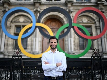 طوني إستانغيه رئيس اللجنة المنظمة لأولمبياد باريس 2024 يقف أمام الحلقات الأولمبية في باريس - 13 مارس 2023 - AFP