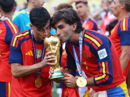 لاعبا المنتخب الإسباني بيدري وفيران توريس يقبلان الكأس أثناء احتفالهما بالفوز بلقب كأس العالم 2026 - 19 يوليو 2026 - Reuters