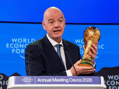 رئيس الاتحاد الدولي لكرة القدم جياني إنفانتينو يحمل كأس العالم خلال الاجتماع السنوي الـ56 للمنتدى الاقتصادي العالمي في دافوس - 22 يناير 2026 - Reuters