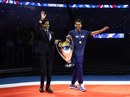 رئيس باريس سان جيرمان ناصر الخليفي وماركينيوس يحملان كأس دوري أبطال أوروبا خلال احتفال في "بارك دي برانس" - 1 يونيو 2025 - Reuters