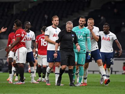 الحكم  جوناثان موس محاطاً باللاعبين بعد أن منح ركلة جزاء لمانشستر يونايتد ضد توتنهام هوتسبير خلال مباراة الفريقين بالدوري الإنجليزي - AFP