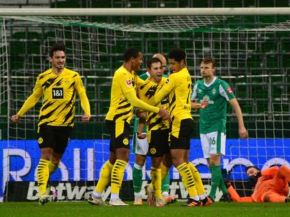 المدافع البرتغالي لفريق دورتموند رافاييل غيريرو يحتفل مع زملائه بعد تسجيله هدفاً في شباك فيردر بريمن - AFP