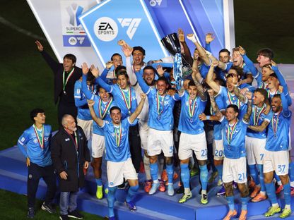 لاعبو نابولي ومدربهم أنطونيو كونتي على منصة التتويج بينما يرفع جيوفاني دي لورينزو كأس السوبر الإيطالي بعد الفوز على بولونيا في النهائي بالرياض - 23 ديسمبر 2025 - REUTERS