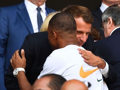 الرئيس الفرنسي إيمانويل ماكرون رفقة نجم منتخب فرنسا كيليان مبابي - AFP