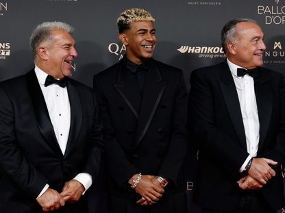 لامين يامال يتوسط جوان لابورتا رئيس نادي برشلونة (يسار) ورافا يوستي نائب الرئيس خلال حفل الكرة الذهبية - 22 سبتمبر 2025 - Reuters