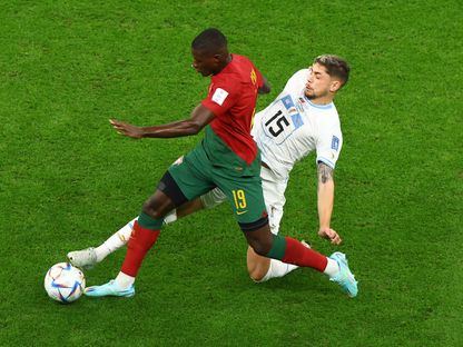 البرتغالي نونو مينديز متجاوزاً الأوروغواياني فيديريكو فالفيردي خلال مباراة المنتخبين في قطر - 28 نوفمبر 2022 - REUTERS