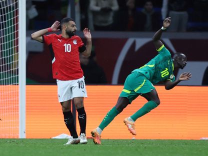 محمد صلاح (يسار) قائد مصر في كرة مشتركة مع السنغالي ساديو ماني - 14 يناير 2026 - Reuters