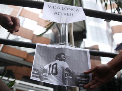صورة لبيليه مع لافتة كُتب عليها "حياة طويلة للملك" خلال وقفة لمشجعين أمام مستشفى ألبرت أينشتاين في ساو باولو - 4 ديسمبر 2022 - REUTERS