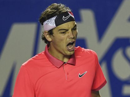 لاعب التنس الامريكي تايلور فريتز يحتفل بإحراز نقطة خلال إحدى المباريات - AFP