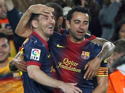 تشافي هيرنانديز وليونيل ميسي يحتفلان بتسجيل هدف لبرشلونة في مرمى ريال بيتيس - 5 مايو 2013 - Reuters