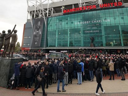 مشجعون لمانشستر يونايتد أمام ملعب "أولد ترافورد" أثناء مرور موكب تشييع بوبي تشارلتون - 13 نوفمبر 2023 - Reuters 