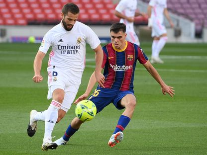 مدافع ريال مدريد الإسباني ناتشو فرنانديز يسيطر على الكرة أمام لاعب برشلونة بيدري - AFP