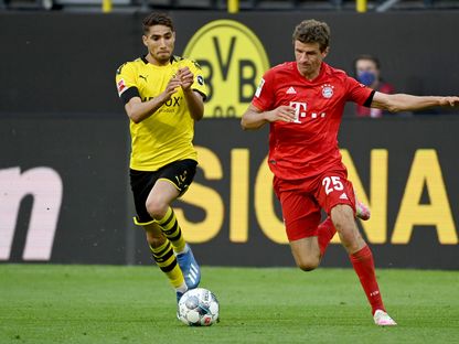 حكيمي في صراع على الكرة مع نجم بايرن ميونيخ توماس مولر - AFP