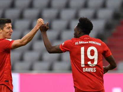 مهاجم بايرن ميونيخ البولندي روبرت ليفاندوفسكي (يسار) يحتفل مع ألفونسو ديفيس - AFP