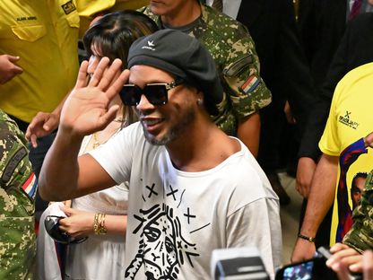  رونالدينيو يلوح عند وصوله إلى مطار سيلفيو بيتيروسي الدولي في باراغواي - Reuters