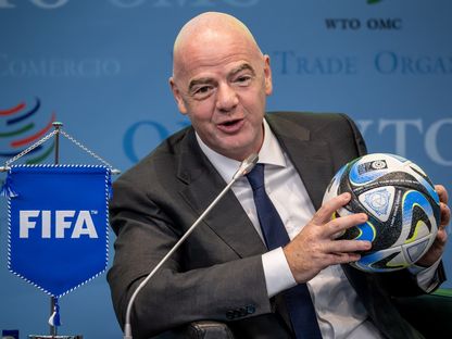 رئيس "فيفا" جياني إنفانتينو يحمل كرة رسمية لكأس العالم للسيدات 2023 خلال نقاش في منظمة التجارة العالمية بجنيف - 1 مايو 2023 - AFP