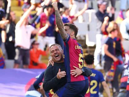 مدرب برشلونة هانزي فليك يحتفل مع إنييغو مارتينيز بعد مباراة ريال مدريد في الدوري الإسباني - 11 مايو 2025 - Reuters