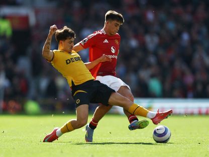 هاري أماس مدافع مانشستر يونايتد في صراع على الكرة مع رودريغو غوميز لاعب ولفرهامبتون - 20 أبريل 2025 - Reuters