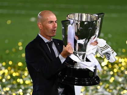 مدرب "ريال مدريد"، الفرنسي زين الدين زيدان، يحتفل بكأس الدوري الإسباني لموسم 2019-2020 في 16 يوليو 2020. - AFP