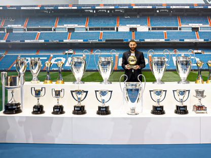 كريم بنزيما يحمل الكرة الذهبية في صورة تذكارية مع كل الألقاب التي فاز بها مع ريال مدريد - 6 يونيو 2023 - TWITTER/@realmadrid