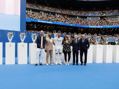 كيليان مبابي متوسّطاً والديه ورئيس ريال مدريد فلورنتينو بيريز وزين الدين زيدان وخوسيه مارتينيز "بيرّي" الرئيس الفخري للنادي في "سانتياغو برنابيو" - 16 يوليو 2024 - realmadrid.com