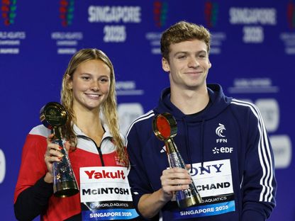 سمر ماكنتوش وليون مارشان بعد فوزهما بجائزتي أفضل سباحة وسباح ببطولة العالم لألعاب الماء - 3 أغسطس 2025 - Reuters