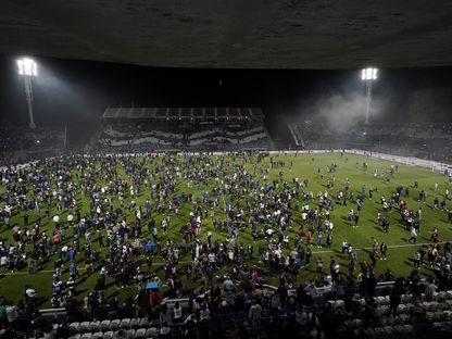 صورة من اجتياح الجمهور للملعب في مباراة بوكا جونيورز وجيمناسيا في الأرجنتين. 6 أكتوبر 2022 - REUTERS