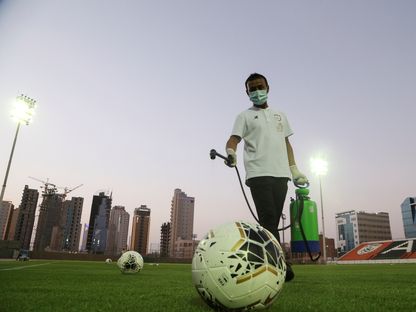 أحد العاملين على تعقيم ملعب تدريبات الشباب السعودي - REUTERS
