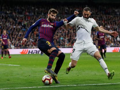 صراع على الكرة بين كريم بنزيمة (يمين) وجيرارد بيكيه في كلاسيكو الدوري الإسباني في 2 مارس 2019 - REUTERS