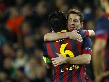 ميسي يعانق زميله تشافي في مباراة برشلونة ومانشستر سيتي بدوري الأبطال - 12 مارس 2014 - REUTERS