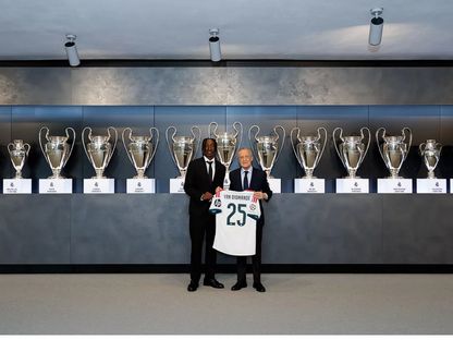 يان ديوماندي مع رئيس ريال مدريد فلورنتينو بيريز خلال تقديمه وبدت خلفهما الكؤوس الـ15 في دوري أبطال أوروبا - 25 أغسطس 2026 - realmadrid.com