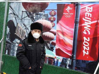 شرطي صيني يرتدي كمامة في إحدى شوارع بكين استعداداً للأولمبياد الشتوي - REUTERS