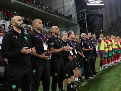وليد الركراكي رفقة طاقمه التدريبي واللاعبين الاحتياطيين أثناء قراءة الفاتحة على روح ضحايا زلزال الحوز - 12 سبتمبر 2023 - AFP