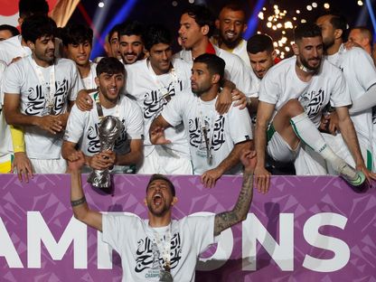 لاعبو منتخب العراق يحتفلون بلقب "خليجي 25" بعد فوزهم على منتخب عُمان في المباراة النهائية بالبصرة - 19 يناير 2023 - AFP