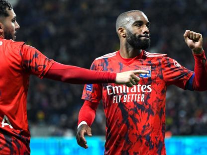 مهاجم أولمبيك ليون ألكسندر لاكازيت (يمين) وزميله ريان شرقي خلال المباراة ضد تولوز في الدوري الفرنسي - 14 أبريل 2023 - AFP