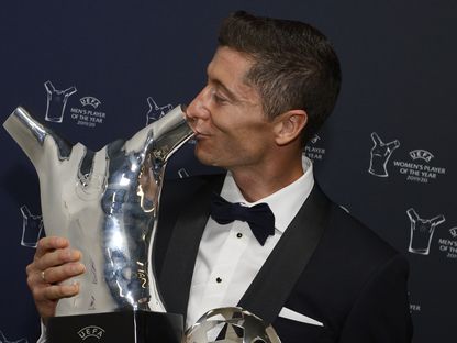 مهاجم بايرن ميونيخ البولندي روبرت ليفاندوفسكي يقبل جائز أفضل لاعب في أوروبا التي فاز بها - AFP