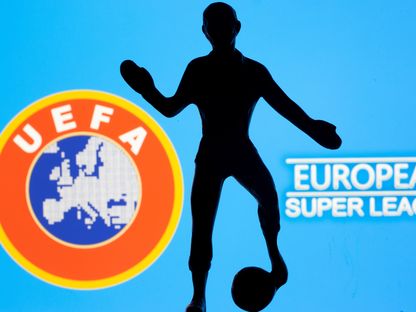 شكل معدني للاعب كرة قدم أمام رسم تعبيري لدوري "سوبر ليغ" وشعار "ويفا" - 20 أبريل 2021 - Reuters 