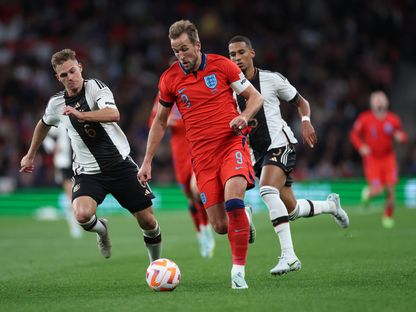 مهاجم منتخب إنجلترا هاري كين يتقدم بالكرة أمام لاعبين من منتخب ألمانيا. 26 سبتمبر 2022  - Reuters