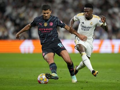 رودري لاعب مانشستر سيتي (يسار الصورة) يسيطر على الكرة من أمام فينيسيوس لاعب ريال مدريد - 9 أبريل 2024 - Reuters