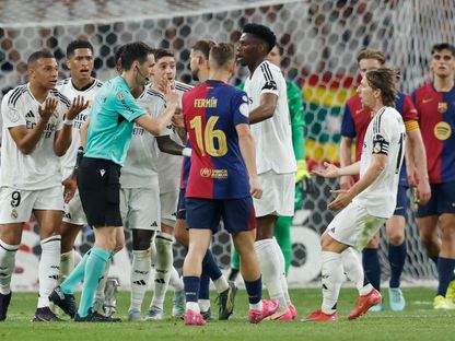 الحكم ريكاردو دي بورغوس يتحدث إلى اللاعبين خلال مباراة نهائي كأس ملك إسبانيا بين برشلونة وريال مدريد - 26 أبريل 2025 - Reuters