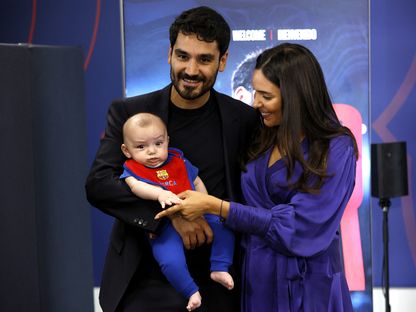 الألماني إيلكاي غوندوغان وزوجته وابنه خلال تقديمه في فريق برشلونة - 17 يوليو 2023 - Reuters