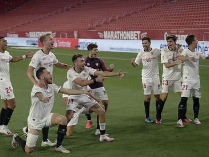 لاعبو "إشبيلية" يحتفلون بالفوز على "ريال بيتيس" أمام مدرجات فارغة - 11 يونيو 2020 - AFP