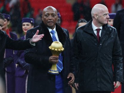 رئيس الاتحاد الإفريقي لكرة القدم باتريس موتسيبي يحمل كأس أمم إفريقيا أثناء سيره بجانب رئيس الفيفا جياني إنفانتينو خلال مراسم التتويج - 18 يناير 2026 - Reuters