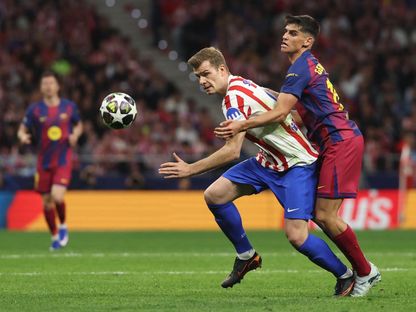 صراع على الكرة بين ألكسندر سورلوث وجيرارد مارتن خلال مباراة بين أتلتيكو مدريد وبرشلونة في دوري أبطال أوروبا - 14 أبريل 2026 - REUTERS