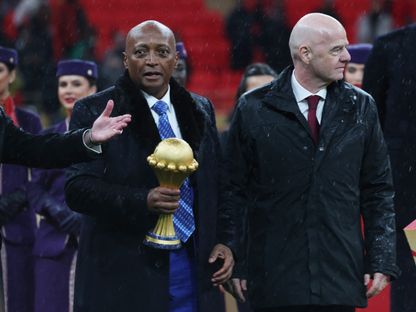 رئيس الاتحاد الإفريقي لكرة القدم باتريس موتسيبي يحمل كأس أمم إفريقيا أثناء سيره بجانب رئيس الفيفا جياني إنفانتينو خلال مراسم التتويج - 18 يناير 2026 - Reuters