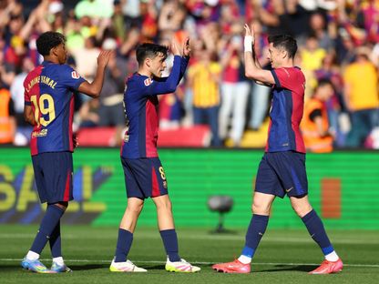 روبرت ليفاندوفسكي مهاجم برشلونة يحتفل بهدفه أمام جيرونا مع زميليه بيدري ولامين يامال بالدوري الإسباني - 30 مارس 2025 - Reuters
