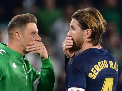 لاعب ريال بيتيس الإسباني خواكين (يسار) ومدافع ريال مدريد سيرجيو راموس - AFP